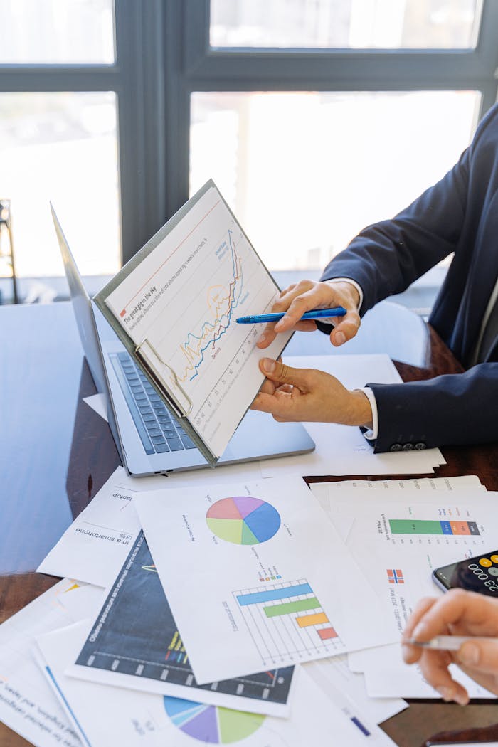 The Art of Drawing Readers In: Your attractive post title goes here Business professionals discussing financial graphs and charts in an office setting.